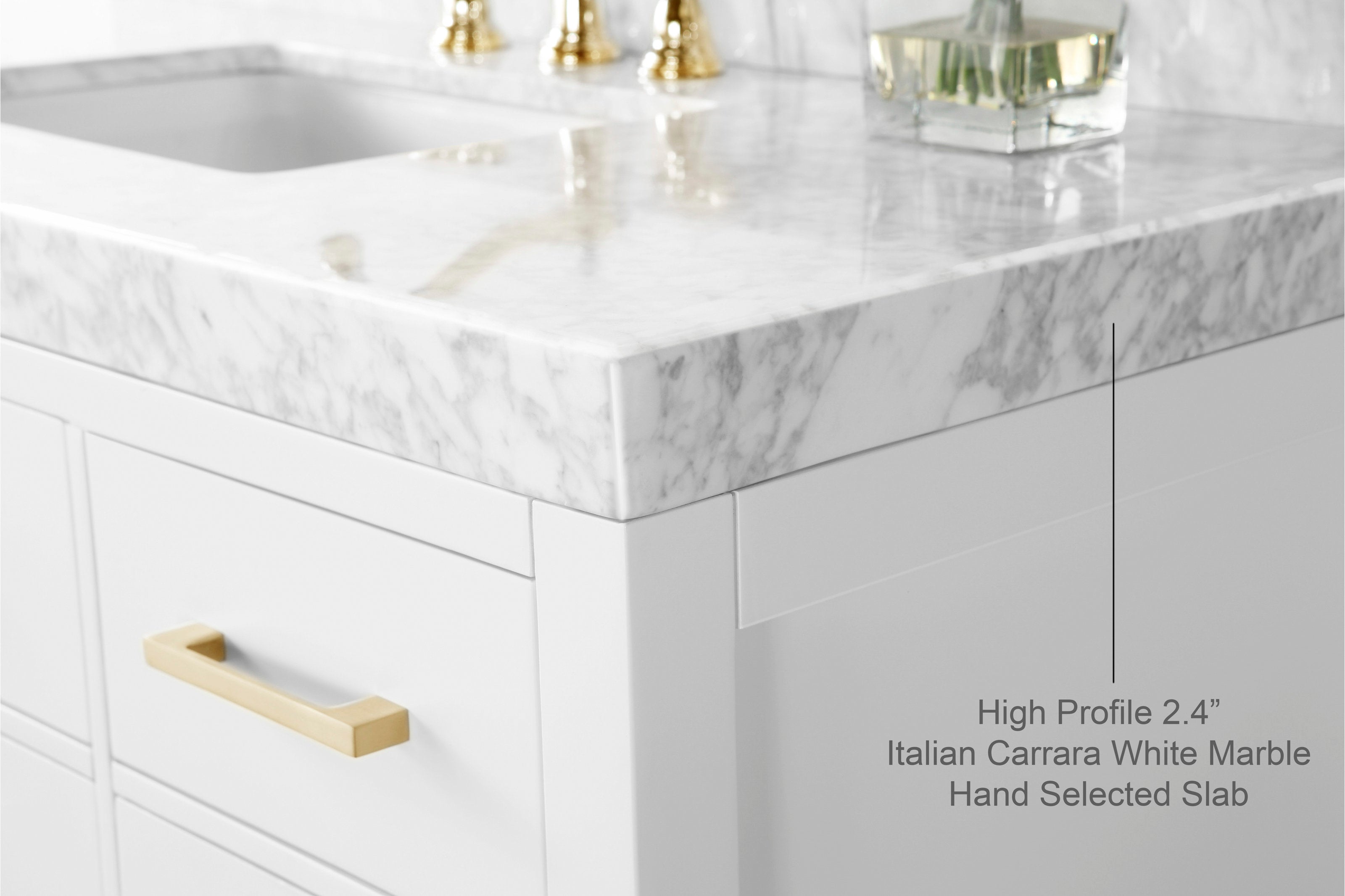Close-up of an Italian Carrara white marble 2.4-inch high-profile countertop and sink corner atop a modern white wood vanity, showing gray veining, a brushed-gold drawer pull and reflected gold faucet hardware.