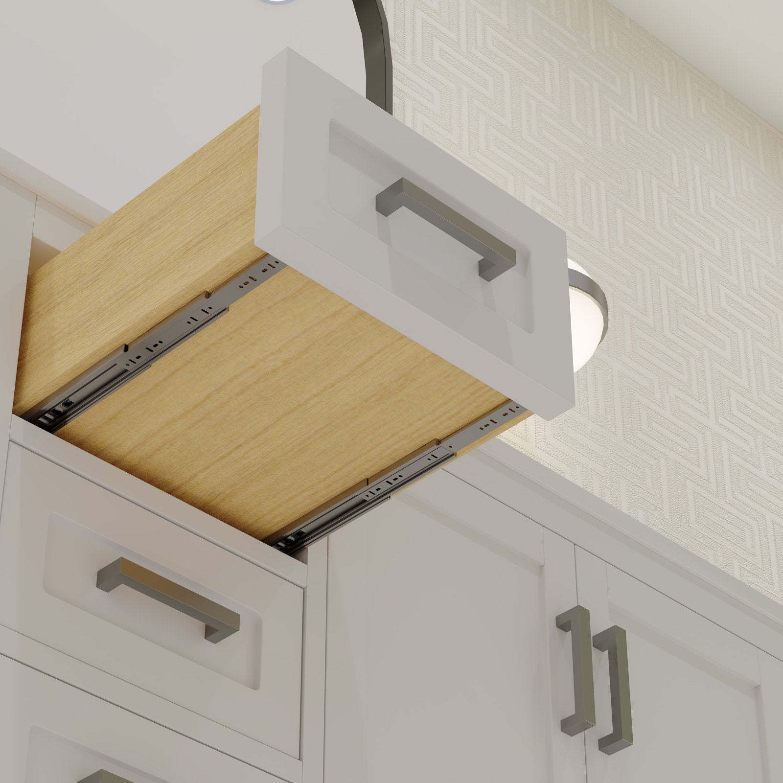 Close-up of a modern stone-colored bathroom vanity with an open solid wood drawer revealing metal undermount slides and a rectangular matte metal handle, with matching cabinet doors and geometric textured wallpaper behind.
