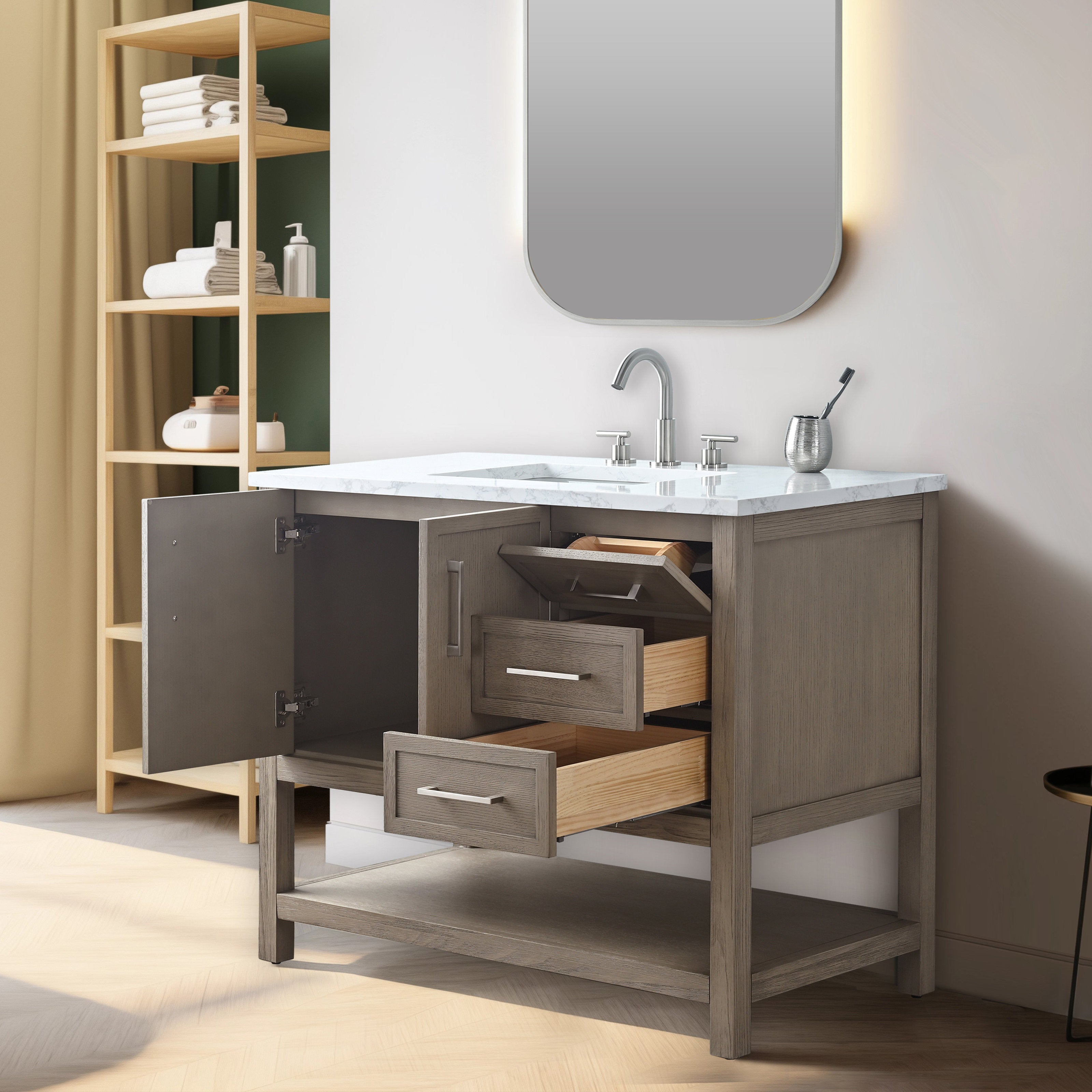 Freestanding modern solid wood bathroom vanity in a stone-gray finish with a white marble top and chrome faucet; left cabinet door and two wood-lined drawers are open, showing storage and an open bottom shelf beneath a rounded mirror.
