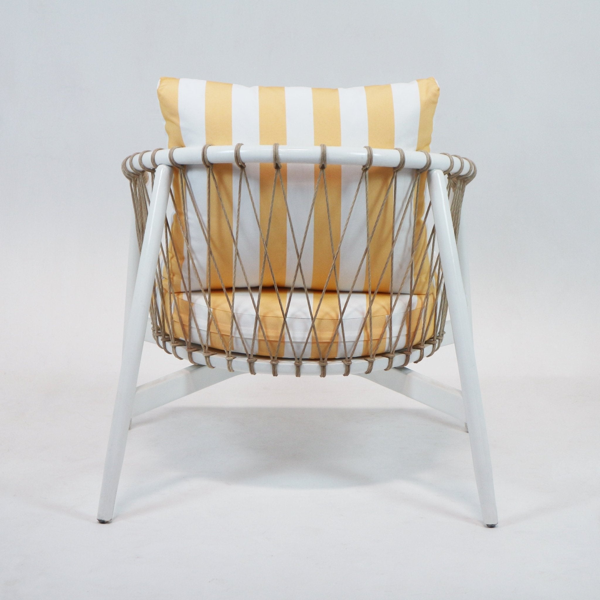 Rear view of a modern outdoor lounge chair with a white painted wood frame, woven natural rope sides, and yellow-and-white striped fabric back and seat cushions.