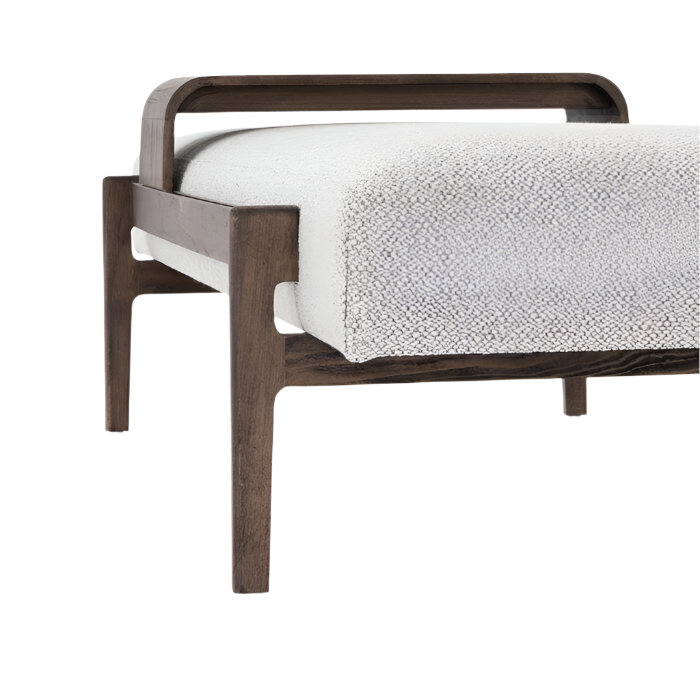 Close-up of a modern end-of-bed bench with white boucle fabric cushion and dark solid wood frame, showing the curved top rail and tapered legs.