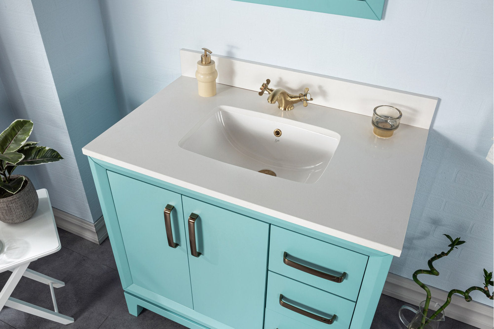 Modern solid-wood turquoise bathroom vanity with white stone countertop, integrated rectangular ceramic sink, brass cross-handle faucet and dark metal pulls, featuring double doors and three drawers in a styled bathroom scene.
