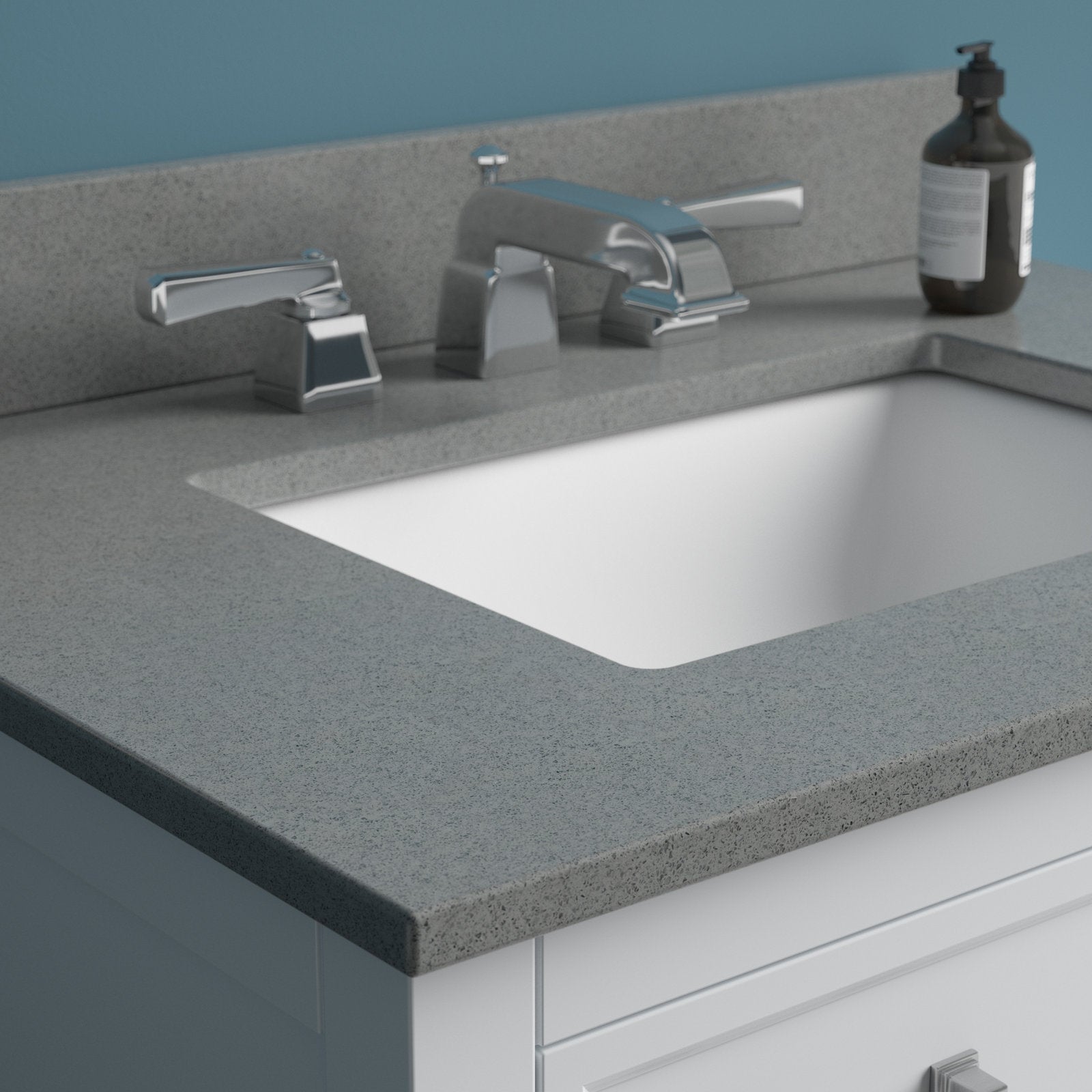 Close-up of a modern bathroom vanity showing a stone-gray countertop with integrated backsplash, white ceramic undermount sink, chrome widespread faucet and handles, and a white solid-wood vanity base with soap dispenser.