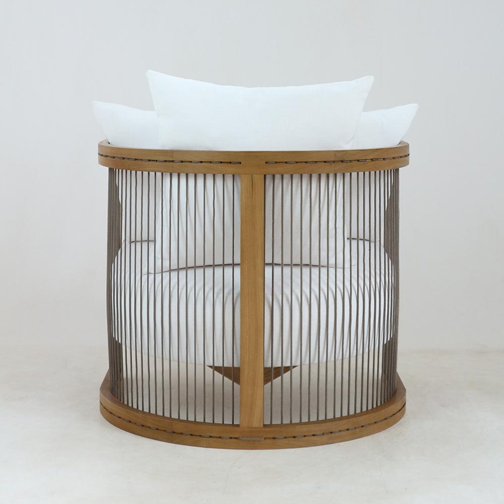 Modern round lounge chair with a natural wood frame and vertical woven rope slats, upholstered in white fabric with a plush white seat cushion and back pillows.