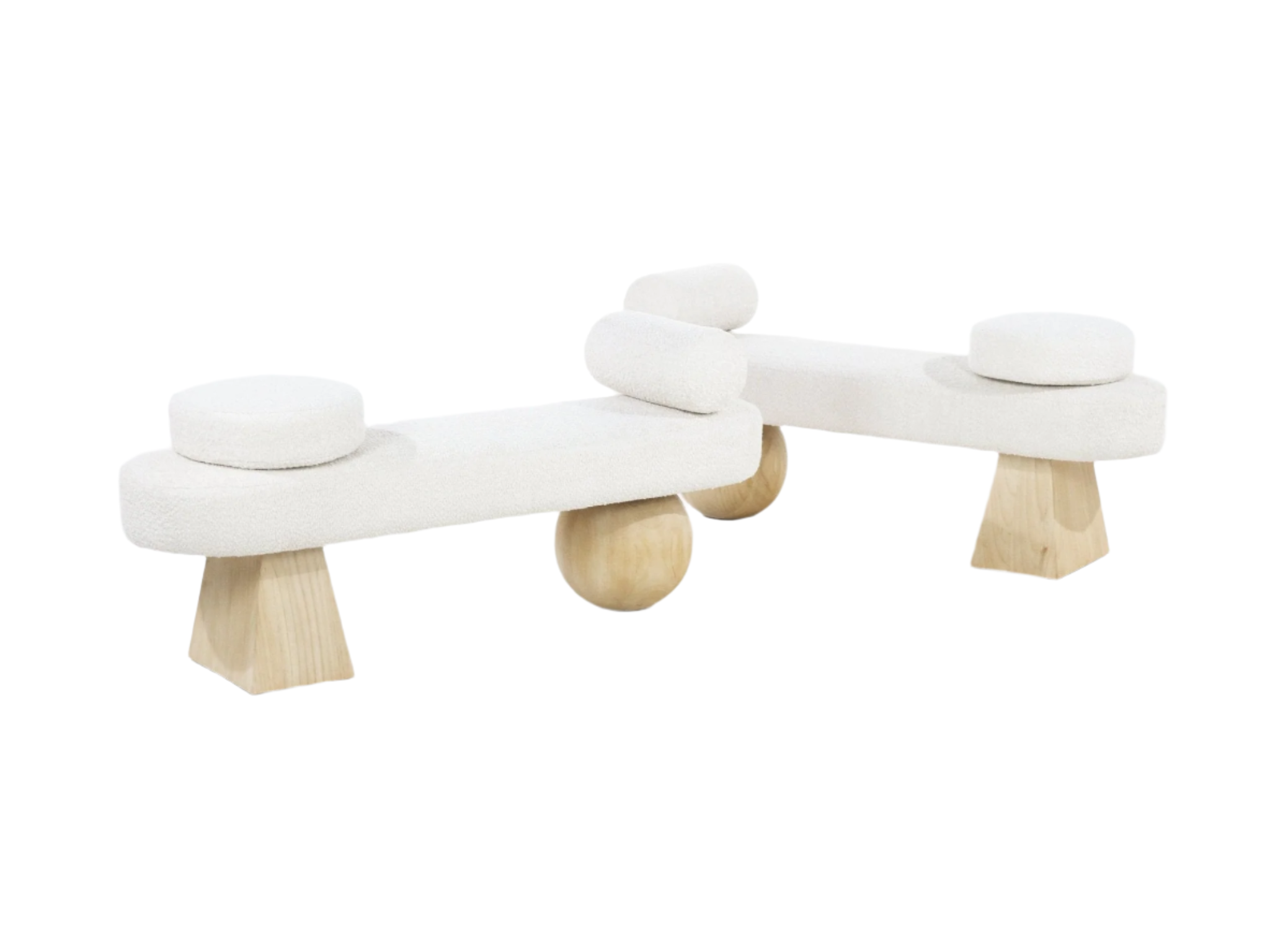 Backless end-of-bed bench upholstered in off-white boucle fabric with round seat cushions and small cylindrical bolsters, supported by natural-finish wooden geometric legs and spherical wood center supports in a modern coastal style.