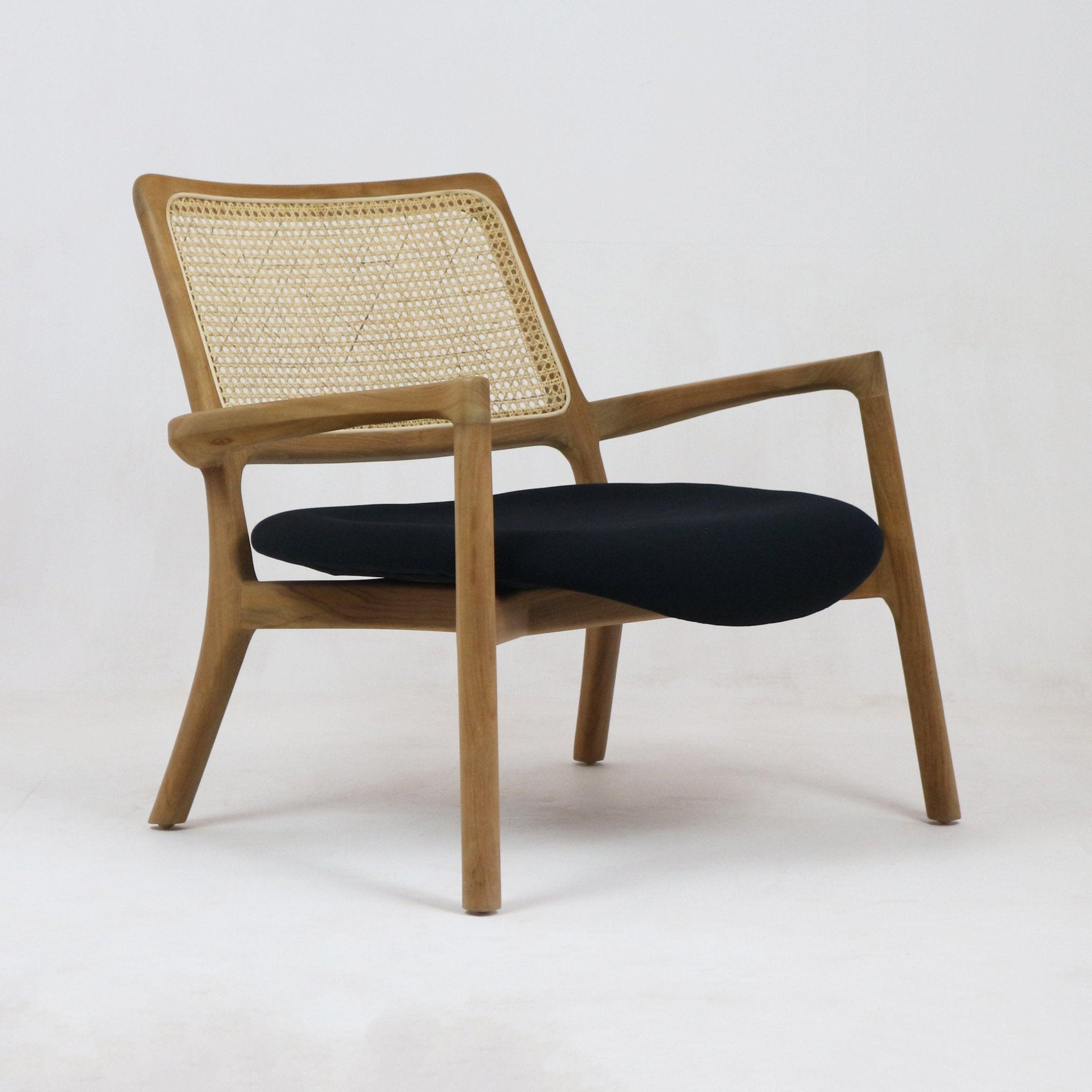 Mid-century modern lounge chair with a teak solid wood frame, woven cane backrest and a black fabric upholstered seat cushion on a white background.
